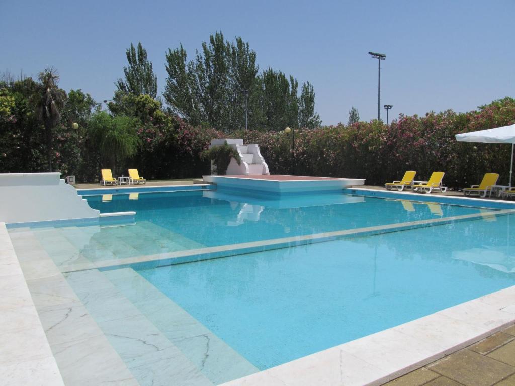 una piscina con acqua blu e sedie gialle di SL Hotel Santa Luzia – Elvas a Elvas