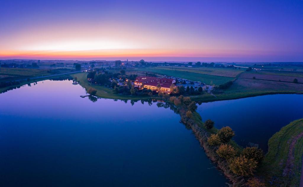 uma vista aérea de um lago ao pôr-do-sol em Dwór Bogucin Hotel&Restauracja em Bogucin