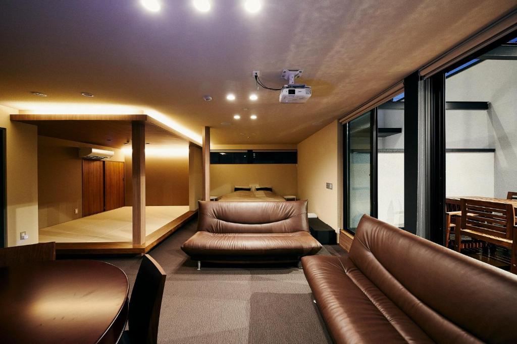 un soggiorno con mobili in pelle e un letto di 634 Condo Shinjuku - Vacation STAY 01902v a Tokyo