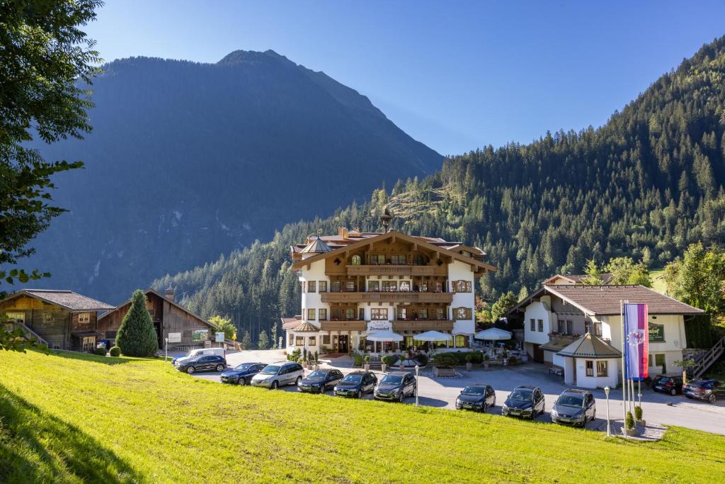 a large building with cars parked in a parking lot at Hotel Dornauhof in Finkenberg