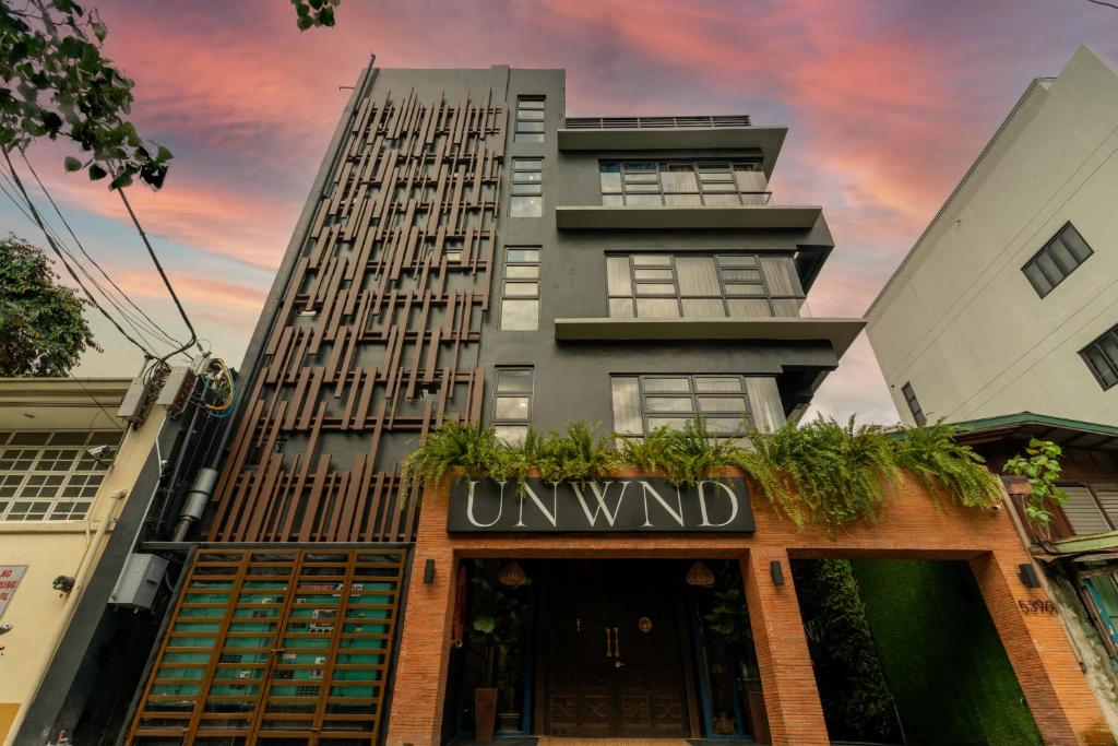 UNWND Boutique Hotel Makati في مانيلا: مبنى طويل مع لوحة مكتوب عليها غير مرغوب فيه