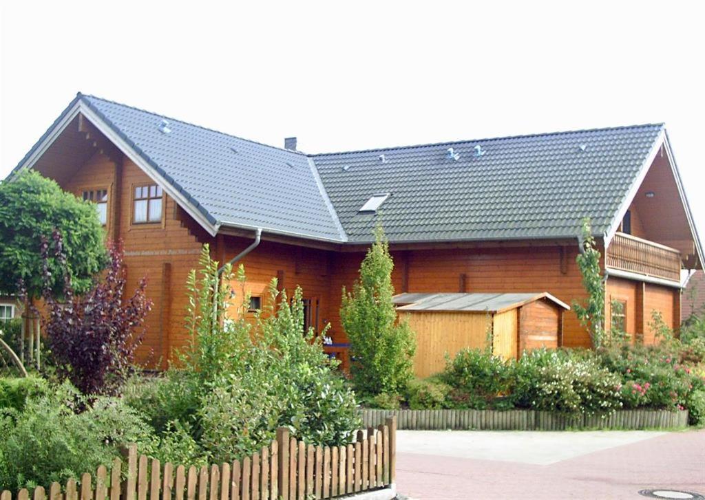 een groot houten huis met een zwart dak bij Reuken - Fewo Zum Emslotsen in Emden