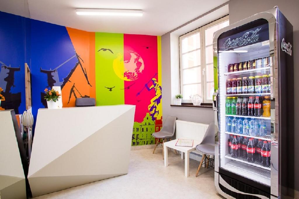 uma máquina de refrigerante num quarto com uma parede colorida em Moon Hostel Gdańsk em Gdańsk