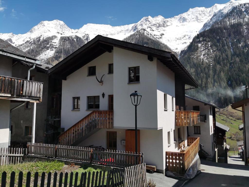 a white building with snow covered mountains in the background at Imseng in Wiler