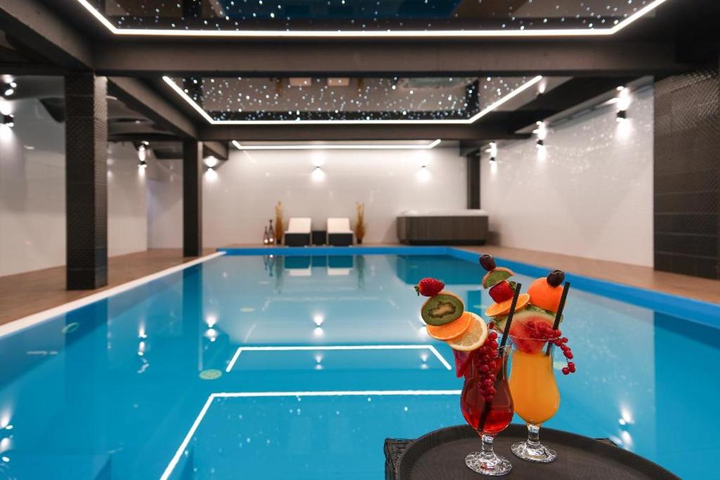 uma piscina com duas figuras à frente em STELLA Resort & SPA em Władysławowo