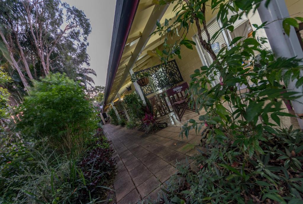 a porch of a house with a bench and plants at Kookaburra Motel Yungaburra in Yungaburra