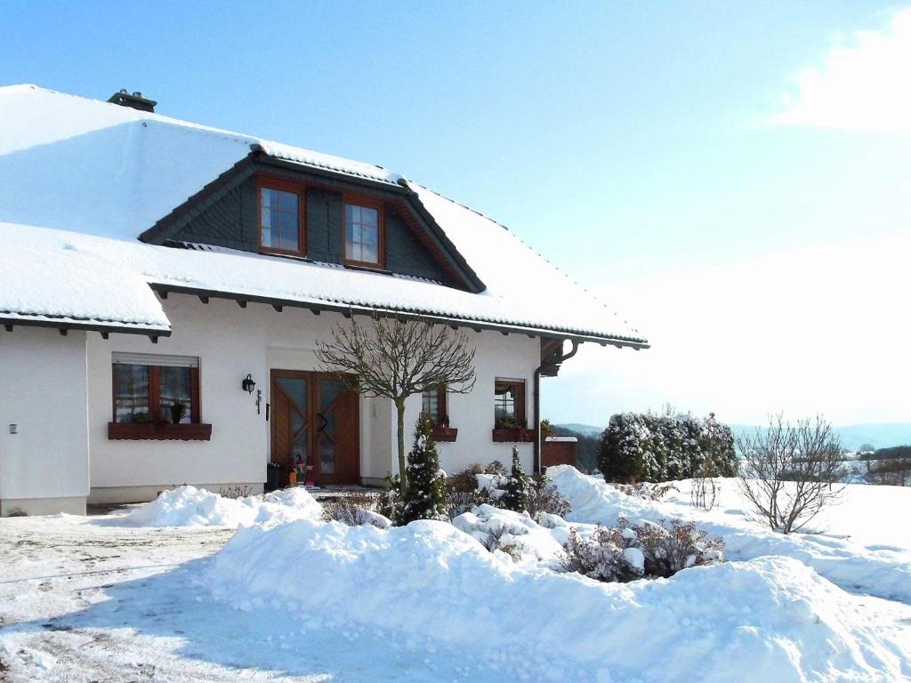 een huis bedekt met sneeuw voor de deur bij Holiday flat in the Sauerland with terrace in Medebach