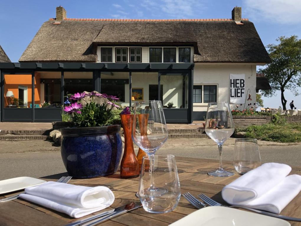 - une table en bois avec des verres à vin et un vase avec des fleurs dans l'établissement Villa BlauwHemel Diever, à Diever