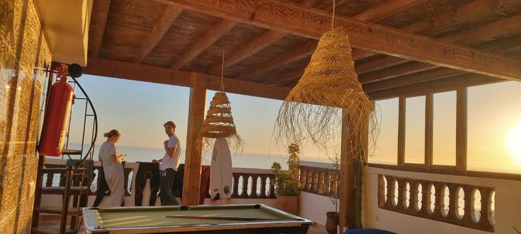 un gruppo di persone che si trova su una terrazza con tavolo da biliardo di GOLVEN Surf a Taghazout