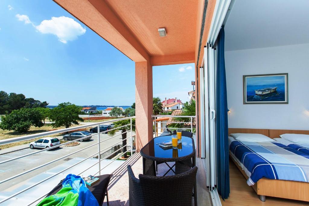 een balkon met een bed en uitzicht op een straat bij Apartments Villa Brioni II in Fažana