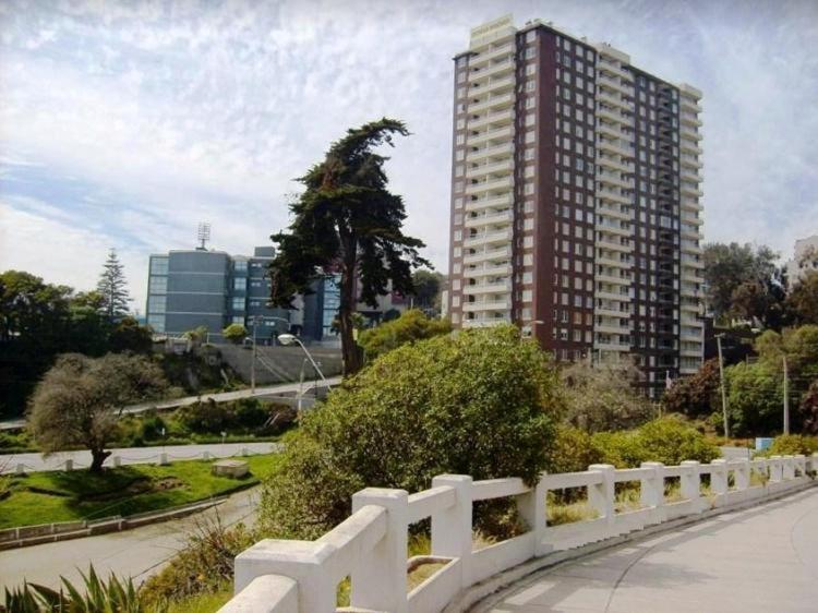 una recinzione bianca di fronte a un palazzo alto di DEPARTAMENTO FRENTE A LA PLAYA 3 personas a Valparaíso