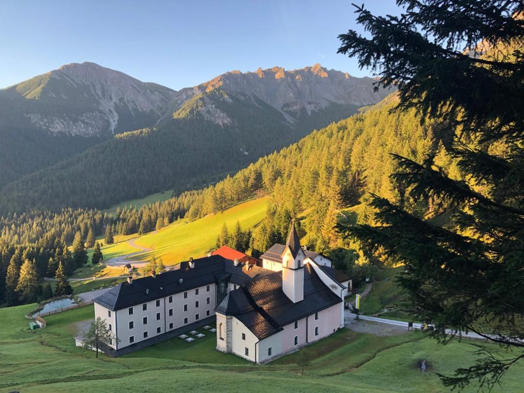 マトライ・アム・ブレンナーにあるMaria Waldrastの山を背景にした丘の上の大きな建物