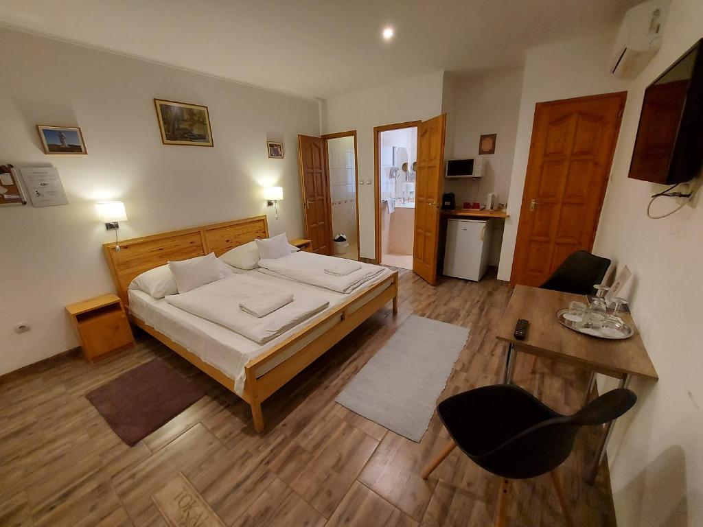 - une chambre avec un lit, une table et une chaise dans l'établissement Böne Vendégház és Borozó, à Tokaj