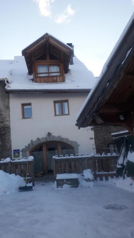 uma casa com neve no chão em frente dela em Le Bacchu Ber em Briançon