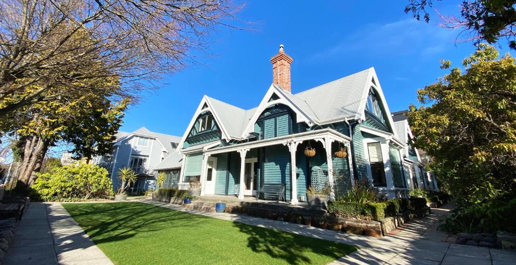 une maison verte avec une cheminée en briques au-dessus dans l'établissement Orari Boutique Hotel, à Christchurch