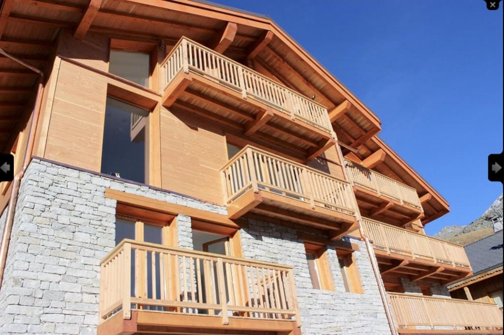 ein Haus mit Holzbalkonen an der Seite in der Unterkunft Chalet Le Quartz in Val Thorens