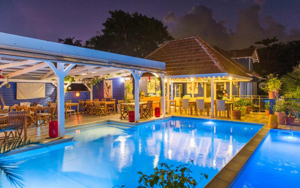 una piscina di fronte a una casa di notte di Hôtel Frégate Bleue a Le François