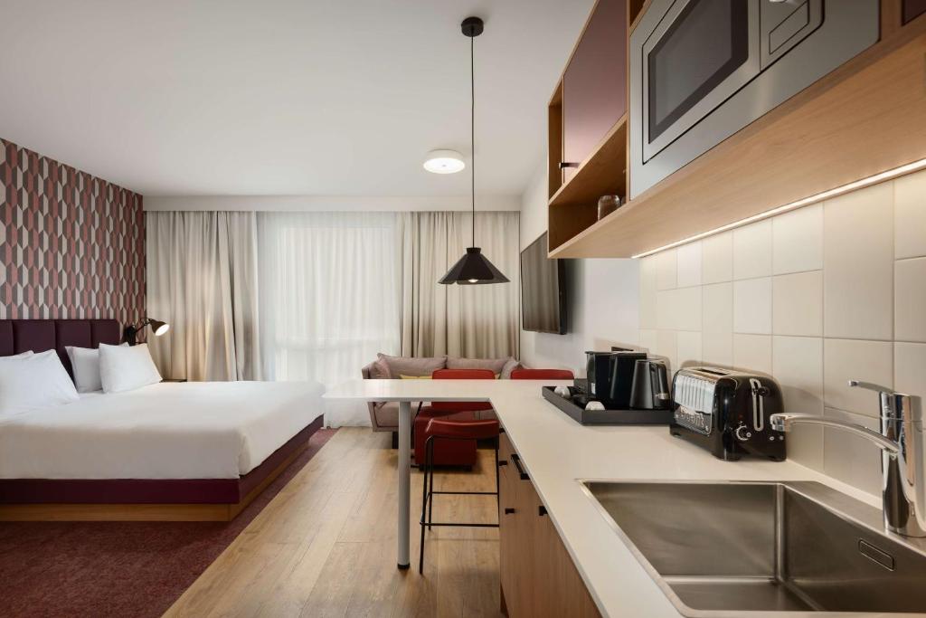 Hyatt House Paris Charles de Gaulle Airport tesisinde bir odada yatak veya yataklar