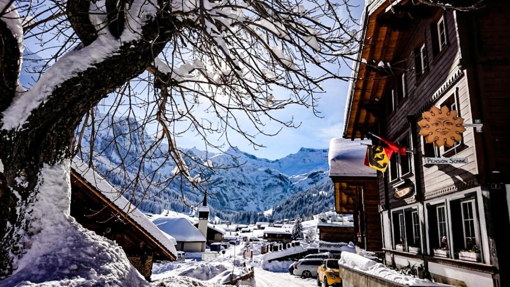 a snow covered town with a snow covered mountain at Pension Sonne in Adelboden