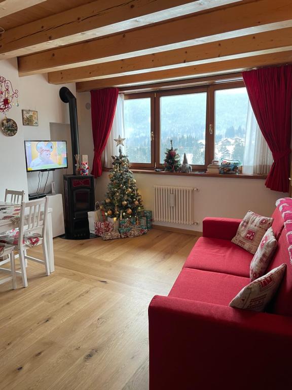 una sala de estar con un árbol de Navidad y un sofá en Casa Romeo, en San Vito di Cadore