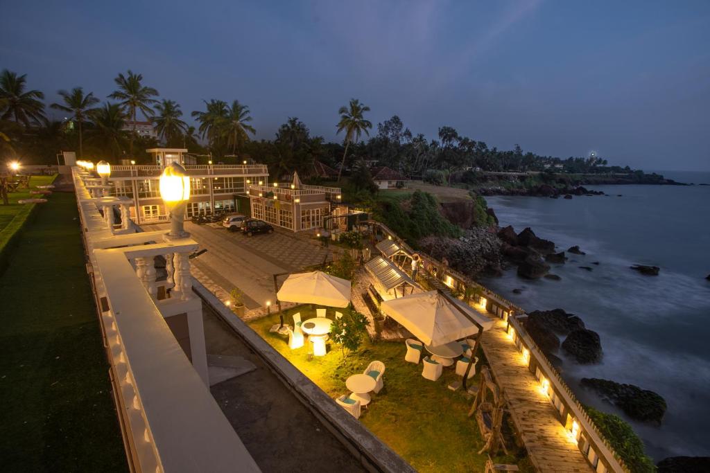 uma vista aérea de uma casa à beira da água à noite em State Beach Resort And Spa em Kannur