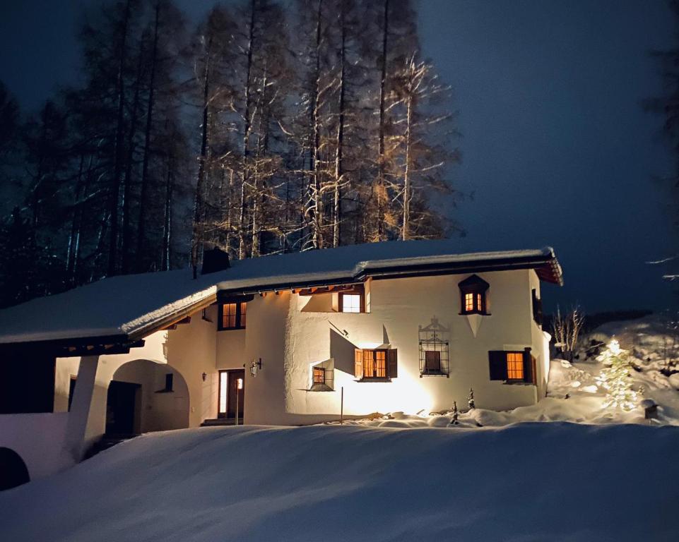 een huis met een kerstboom in de sneeuw bij Chalet Chesa Surlej, Davos in Davos