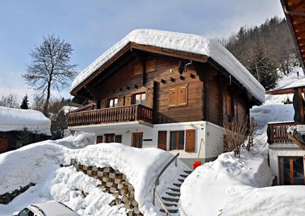 a wooden house with snow on the ground at Stachelbeere OG in Fiesch