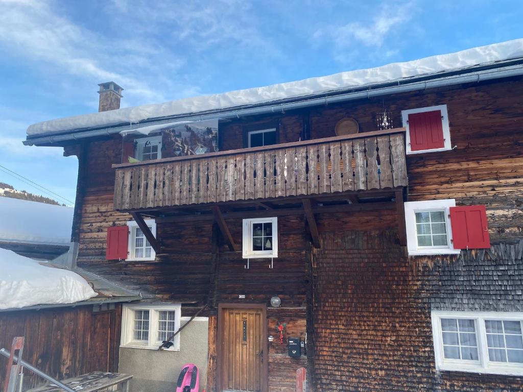 uma casa de madeira com uma varanda em cima em Tgesa Frena em Sedrun