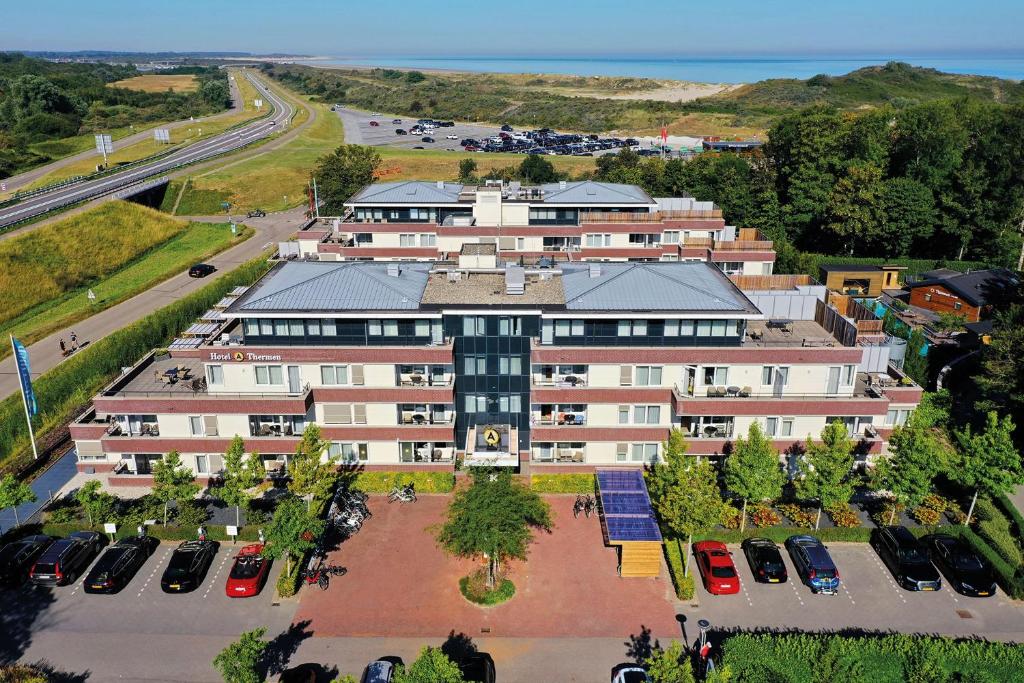 een luchtzicht op een gebouw met een parkeerplaats bij Fletcher Wellness-Hotel Kamperduinen in Kamperland