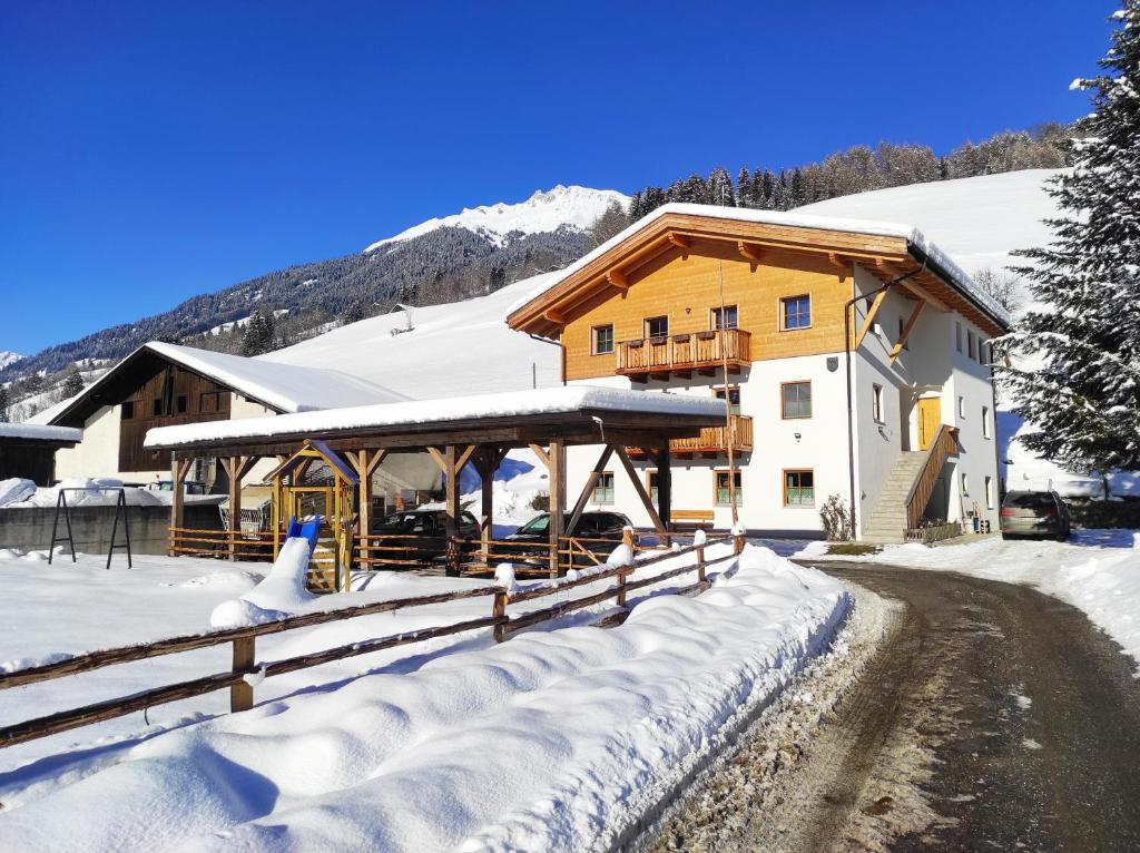 uma casa na neve com uma cerca em Nestlhof em Vipiteno