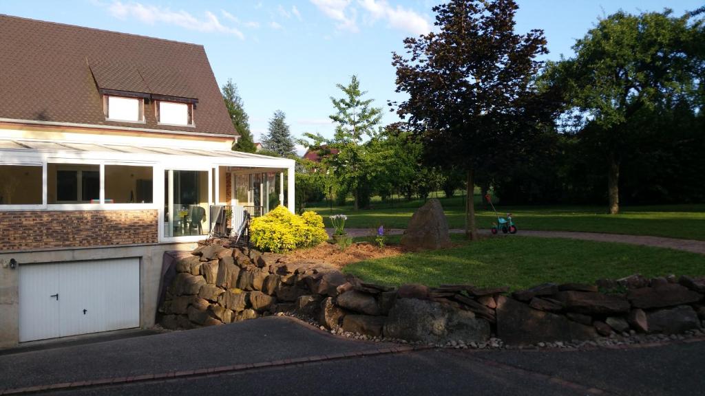 une maison avec un mur en pierre à côté d'une cour dans l'établissement Villa/Appartement au coeur des vignes ***, à Barr