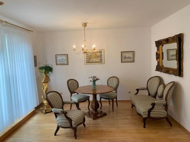 a dining room with a table and chairs and a mirror at Amadeus Apartment in Baden