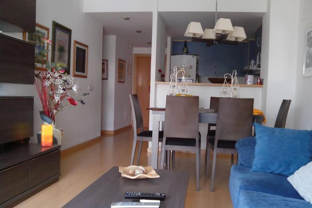 a living room and kitchen with a table and chairs at Bonito apartamento de 3 hab. con jardín in Roses