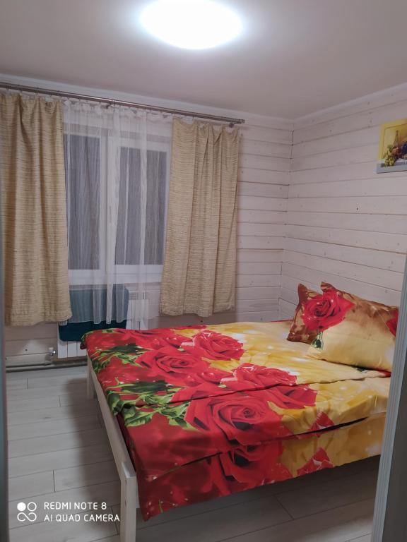 Un dormitorio con una cama con flores rojas. en Good House, en Slavske