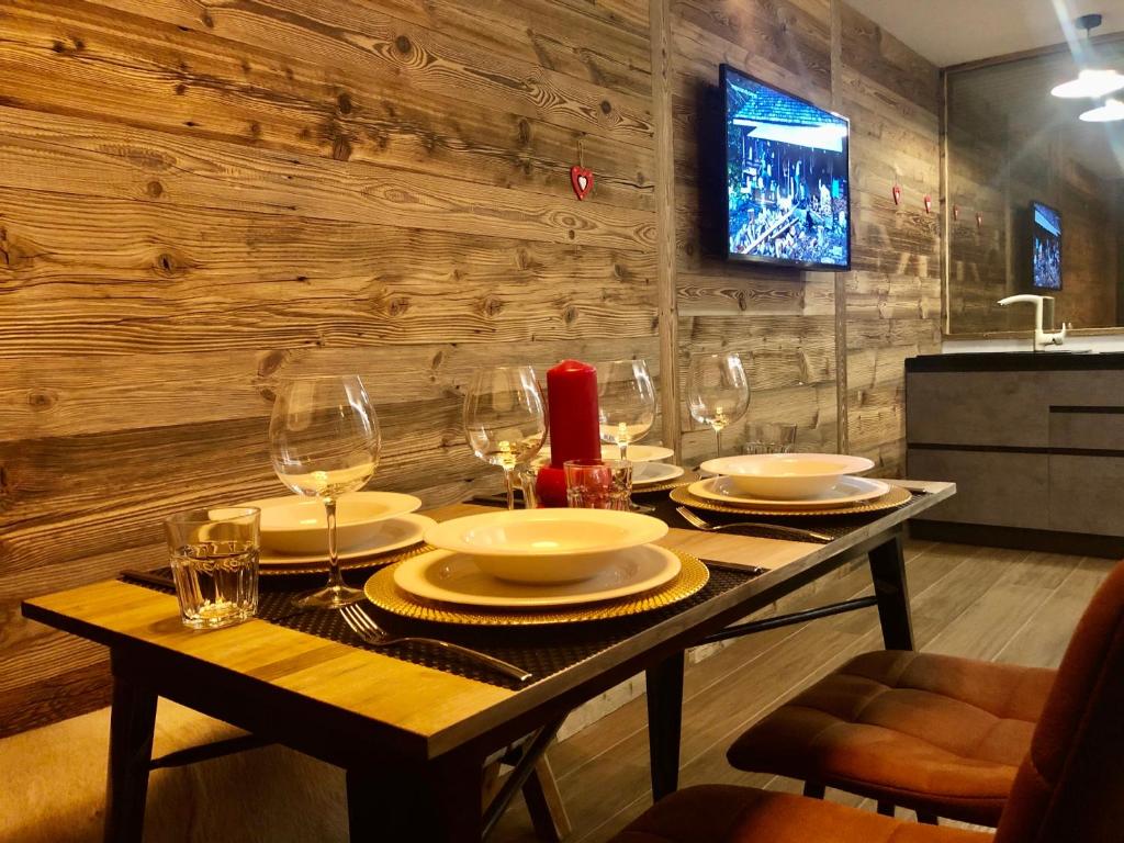 - une table avec des assiettes et des verres à vin dans l'établissement Central Apart Chalet, à Breuil-Cervinia