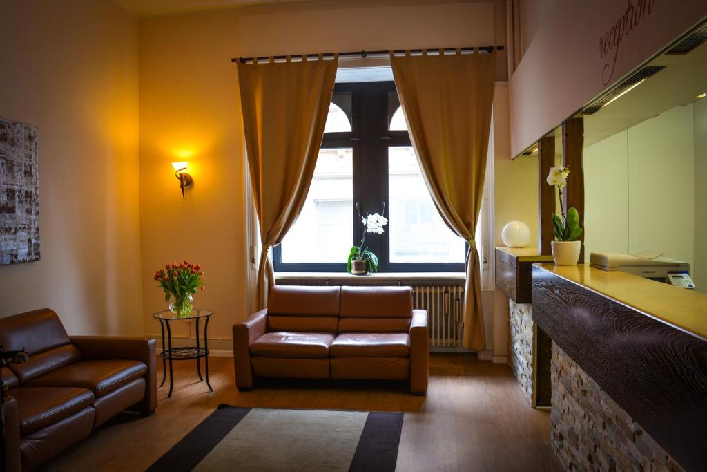 - un salon avec un canapé et une chaise dans l'établissement Hotel am Landeshaus, à Wiesbaden