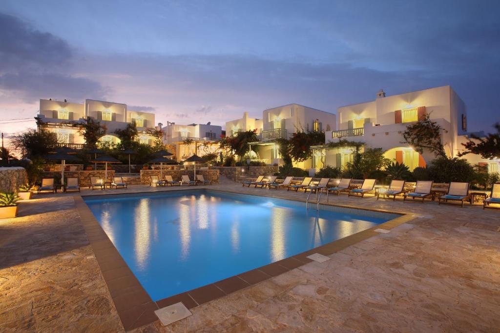 une piscine avec des chaises et des bâtiments en arrière-plan dans l'établissement Aeolos Hotel, à Koufonisia