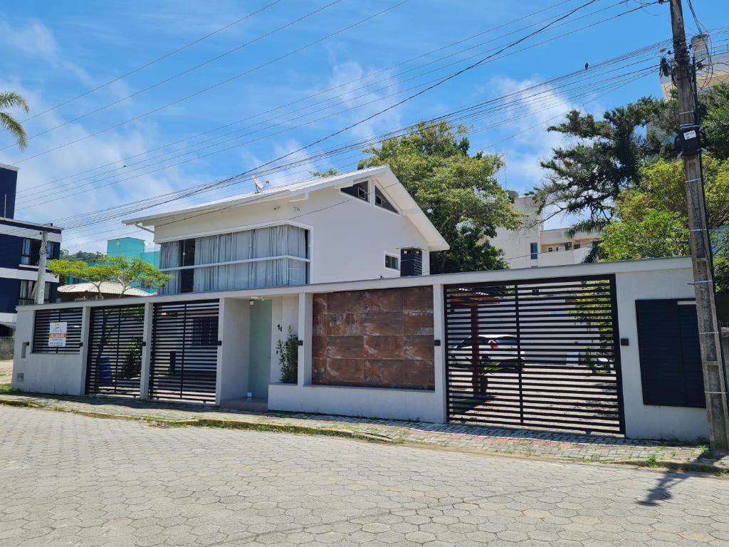 邦比尼亚斯Residencial Rumo ao Mar - Bombinhas-SC的街上的白色房子,有金属车库门