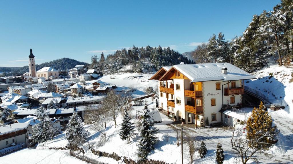 a small town in the snow with a church at Appartements Plattnerhof in Castelrotto