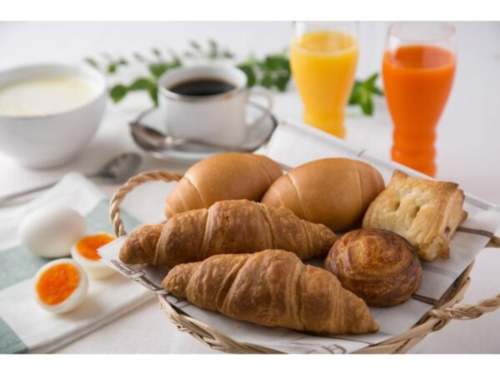 een bord brood en croissants op een tafel bij R&B Hotel Kumagaya Ekimae - Vacation STAY 14849v in Kumagaya