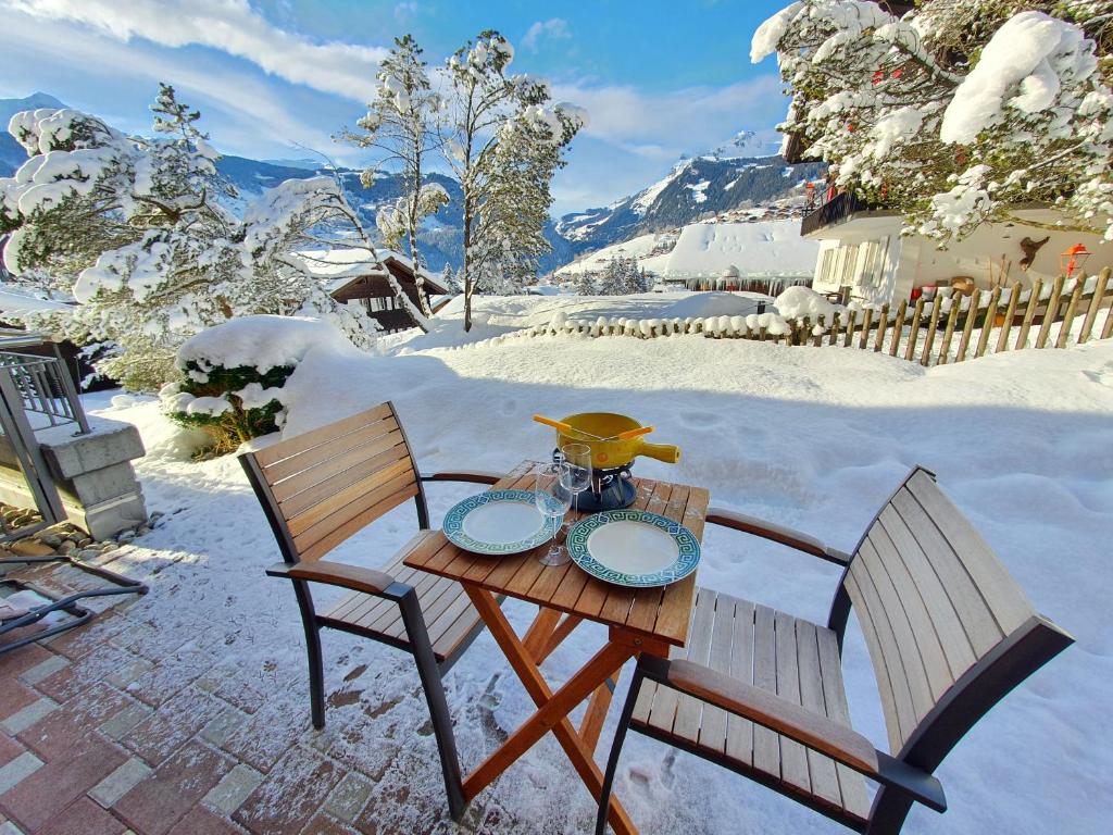 stół i dwa krzesła na śniegu w obiekcie MOM - Alpine Boutique Apartments, Chalet Fagus, Terrace Studio w mieście Grindelwald