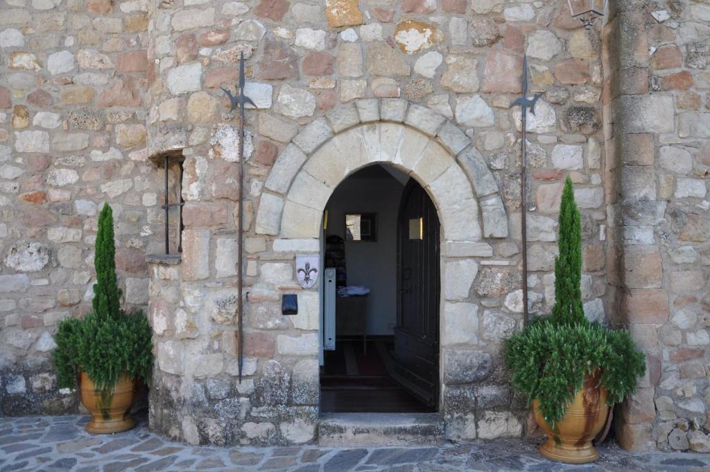 una entrada a un edificio de piedra con dos macetas en Le Château d'Argens, en Les Arcs sur Argens