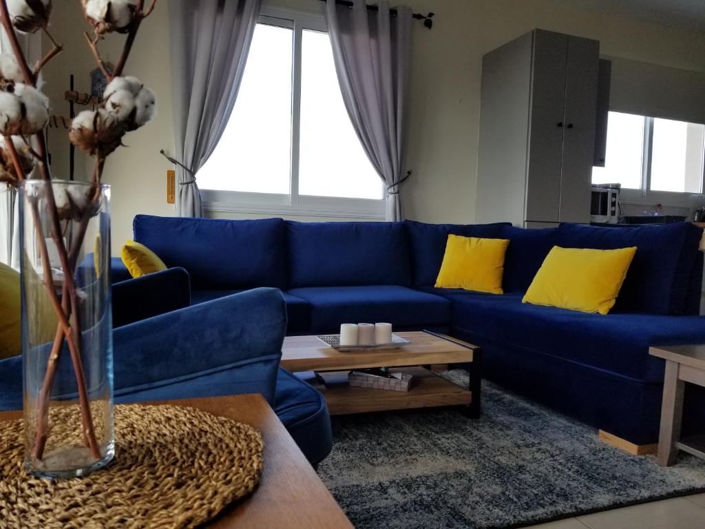 Sofá azul en la sala de estar con almohadas amarillas en Penthouse Apartment Universal, en Pafos