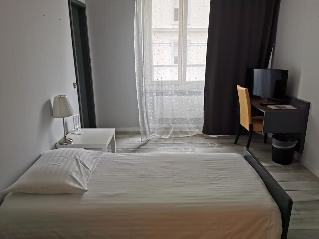 - une chambre avec un lit, un bureau et une fenêtre dans l'établissement Hotel Fleur-de-Lys, à La Chaux-de-Fonds