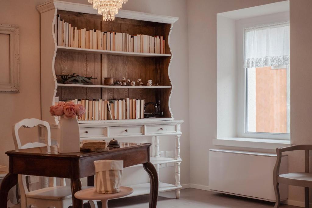 une chambre avec une table et une étagère avec des livres dans l'établissement Il cantuccio sul Garda - Relais di charme, à Cavaion Veronese