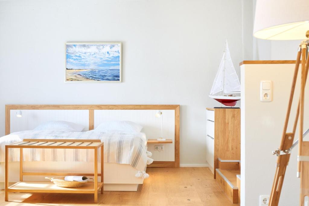 Schlafzimmer mit einem Bett und einem Tisch in der Unterkunft Pierspeicher Boardinghouse in Kappeln