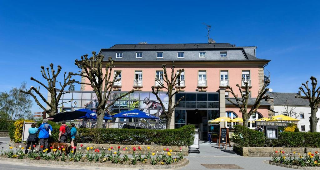 a group of people standing in front of a building at Trail-Inn Natur & Sporthotel in Berdorf