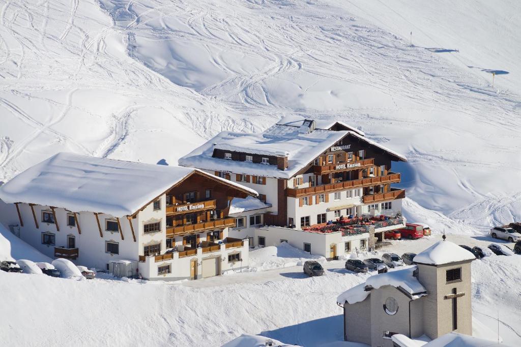 Un bâtiment dans la neige avec de la neige dans l'établissement Hotel Enzian, à Zürs