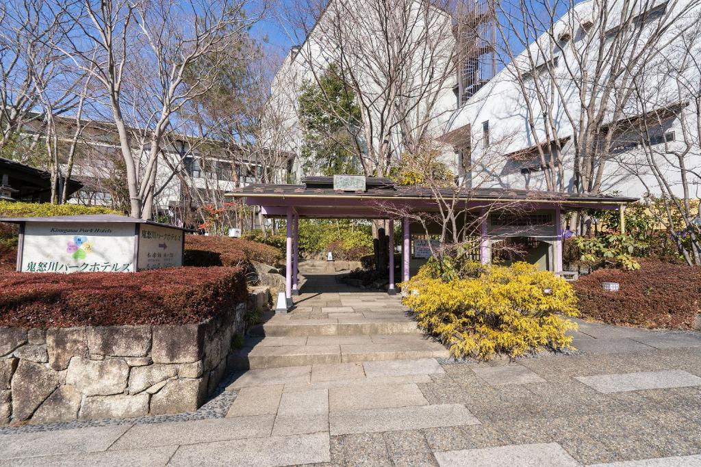 een loopbrug in een park voor een gebouw bij Tabist Kinugawa Park Cottage in Nikko