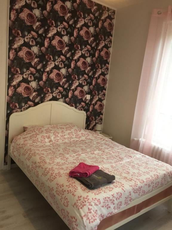 - une chambre avec un lit orné d'un mur fleuri dans l'établissement La Vie est Belle, à Abbeville